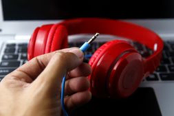 mano sujetando cable de auriculares rojos
